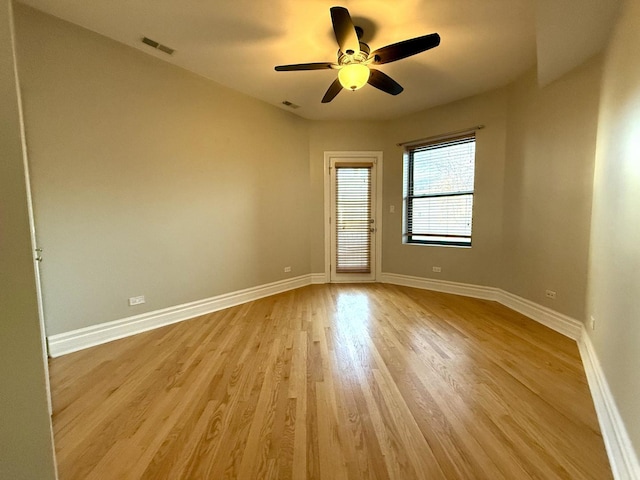 unfurnished room featuring light wood-style floors, visible vents, and baseboards