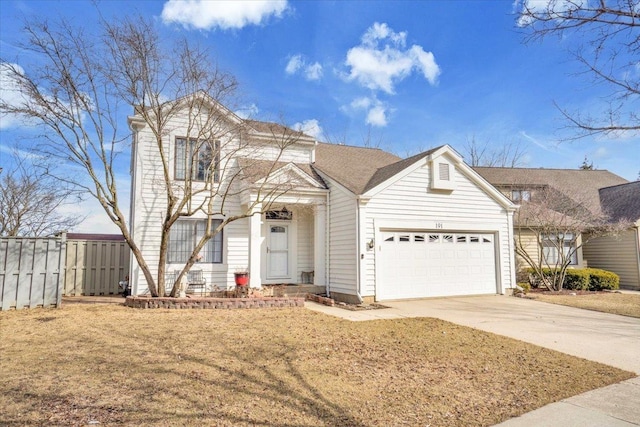 traditional home with driveway, an attached garage, and fence