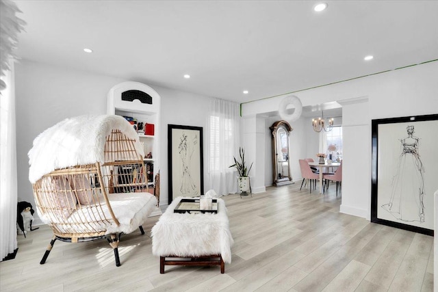 sitting room with light wood-type flooring, an inviting chandelier, and recessed lighting