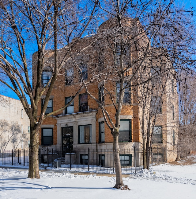 multi unit property with a fenced front yard and brick siding