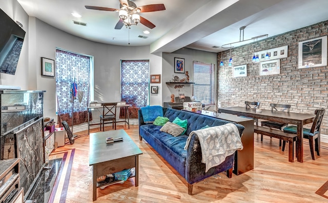 living area with light wood finished floors, visible vents, and a ceiling fan