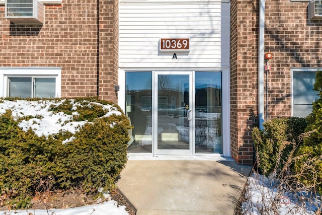 property entrance featuring brick siding