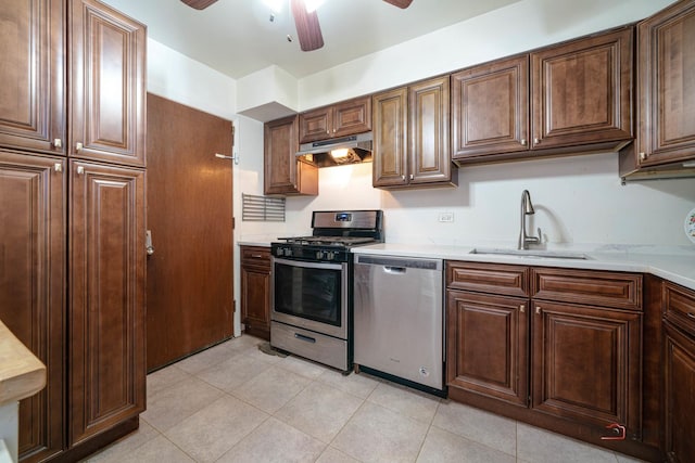 kitchen with light tile patterned floors, ceiling fan, appliances with stainless steel finishes, under cabinet range hood, and a sink