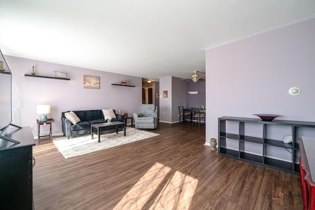 living room with wood finished floors, a ceiling fan, and baseboards