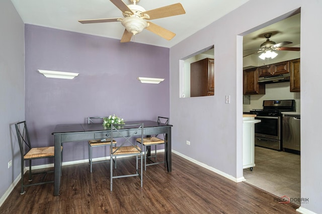 dining room with a ceiling fan, baseboards, and wood finished floors