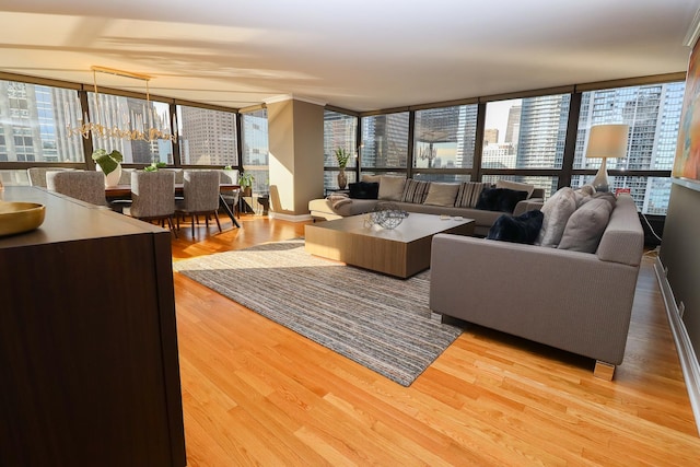 living room featuring light hardwood / wood-style floors, a wealth of natural light, a chandelier, and floor to ceiling windows