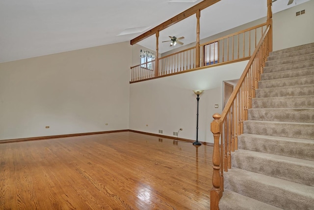 unfurnished living room featuring hardwood / wood-style floors, ceiling fan, high vaulted ceiling, and beamed ceiling