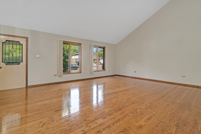 unfurnished room with high vaulted ceiling and light hardwood / wood-style flooring