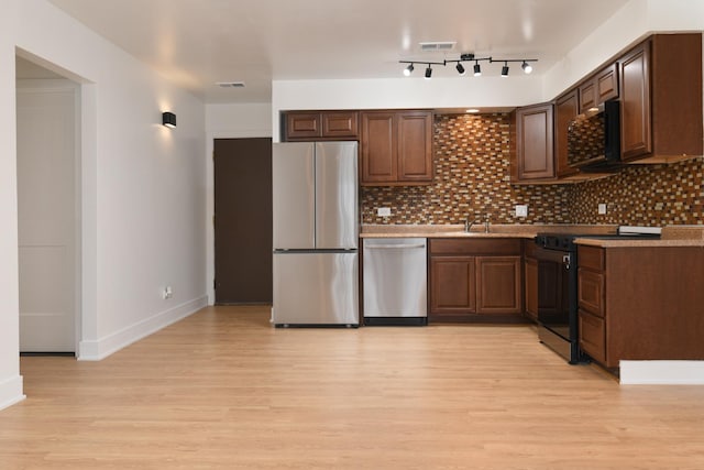 kitchen with visible vents, light wood-type flooring, decorative backsplash, and appliances with stainless steel finishes