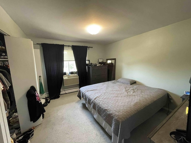 bedroom with a baseboard heating unit and light colored carpet