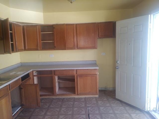 kitchen with brown cabinets, light countertops, and open shelves