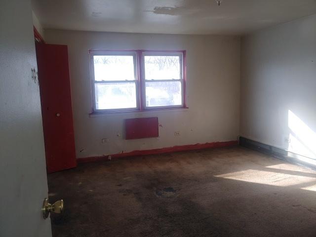 carpeted empty room featuring baseboards