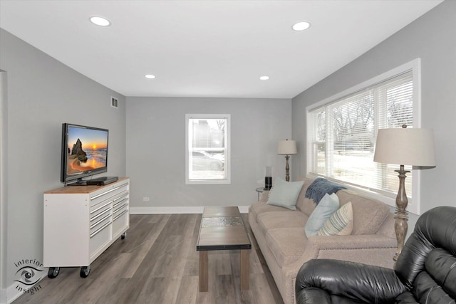 living area featuring baseboards, dark wood-style flooring, visible vents, and recessed lighting