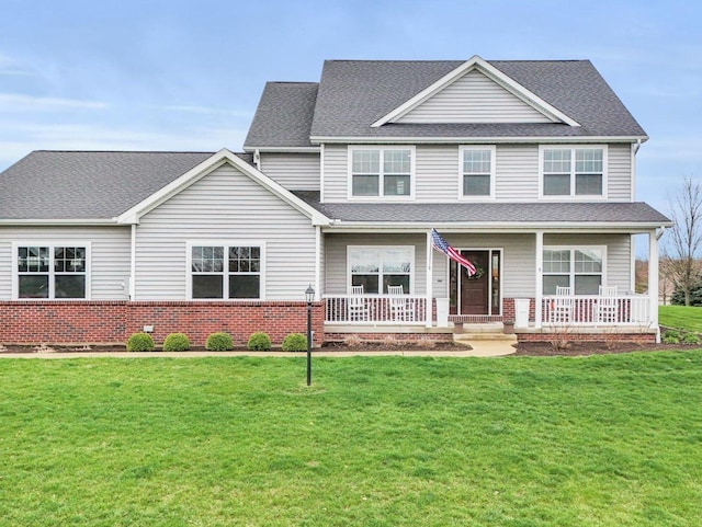 5 Fieldcrest Dr, Monticello, IL 61856 - view of front facade featuring covered porch, roof with shingles, brick siding, and a front lawn