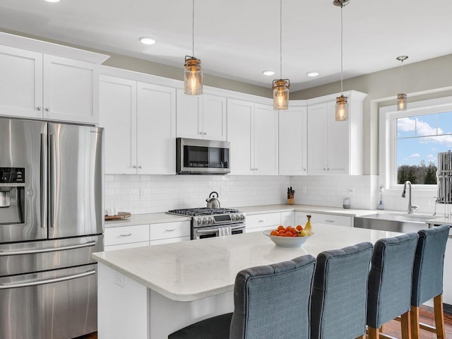 5 Fieldcrest Dr, Monticello, IL 61856 - kitchen featuring stainless steel appliances, a breakfast bar, a sink, white cabinets, and tasteful backsplash