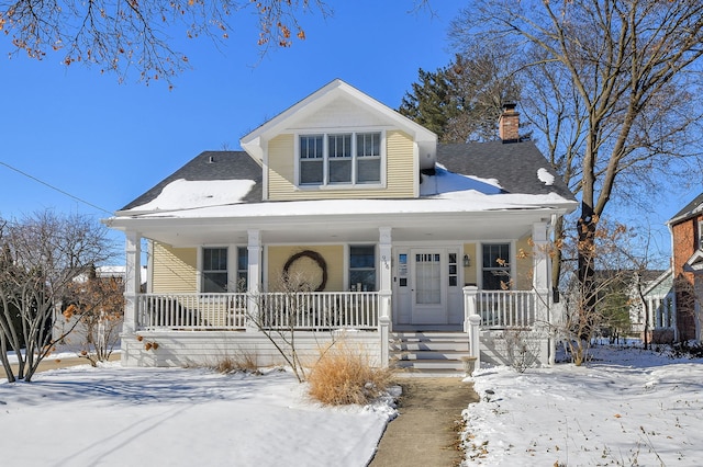 bungalow featuring a porch and a chimney