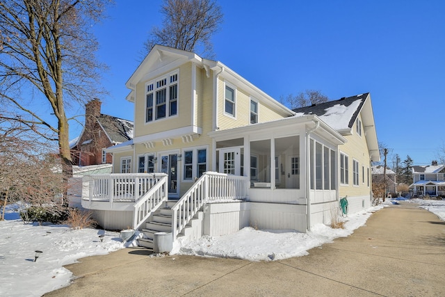 view of front facade featuring a sunroom and stairway