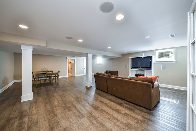 living area featuring decorative columns, visible vents, wood finished floors, and recessed lighting