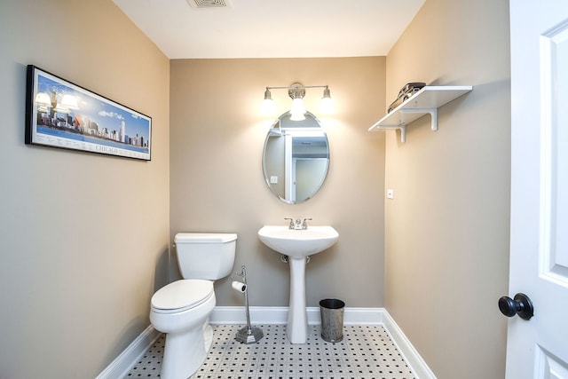 half bath featuring visible vents, toilet, and baseboards