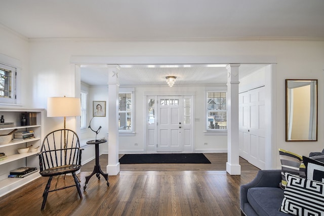 foyer with crown molding, baseboards, wood finished floors, and ornate columns