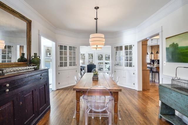 dining space with crown molding and dark wood-style flooring