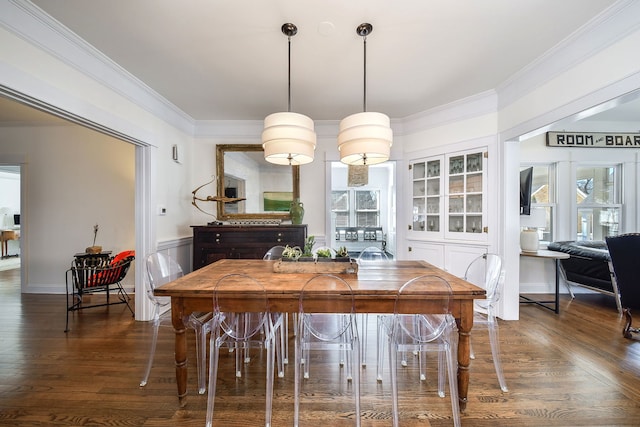 dining room with a wainscoted wall, crown molding, and wood finished floors