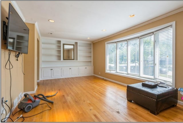 living area with baseboards, light wood-style floors, and crown molding