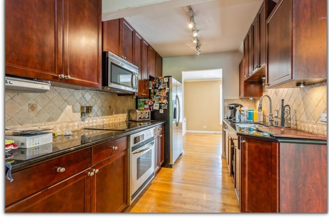 kitchen featuring light wood-style flooring, reddish brown cabinets, a sink, and appliances with stainless steel finishes