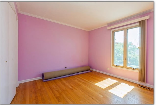 empty room with crown molding, visible vents, baseboards, and light wood-type flooring