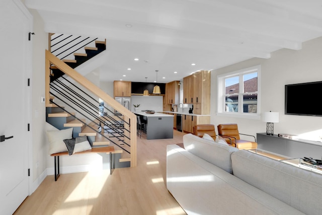 living room with light hardwood / wood-style flooring and beamed ceiling