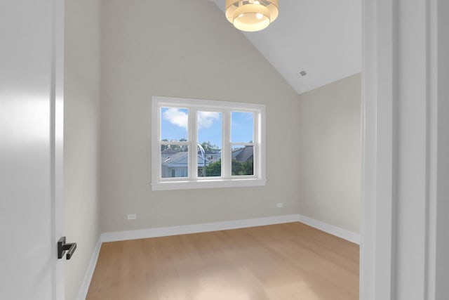 empty room featuring lofted ceiling and light hardwood / wood-style floors