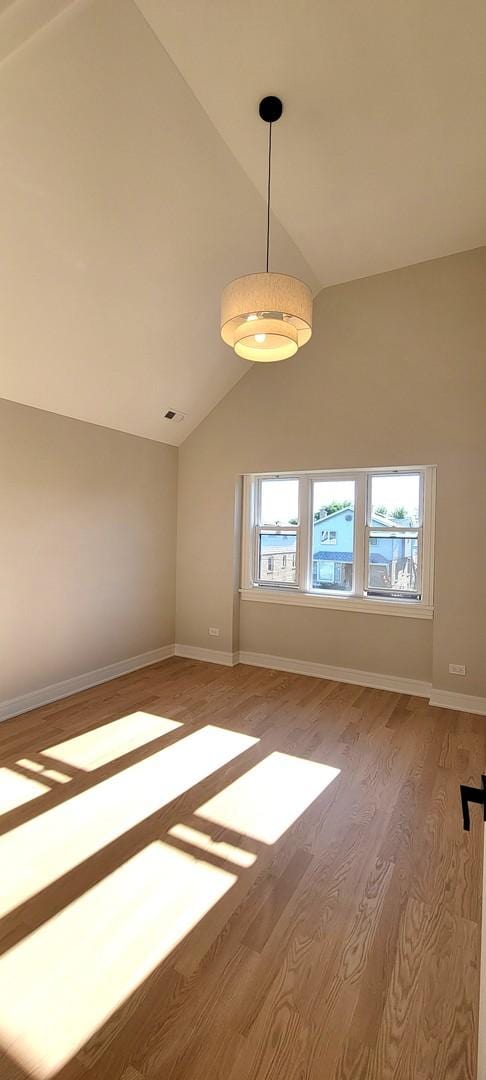 empty room featuring hardwood / wood-style flooring and vaulted ceiling