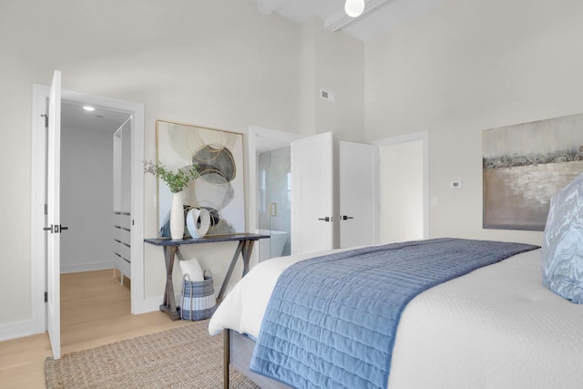 bedroom featuring beam ceiling and high vaulted ceiling