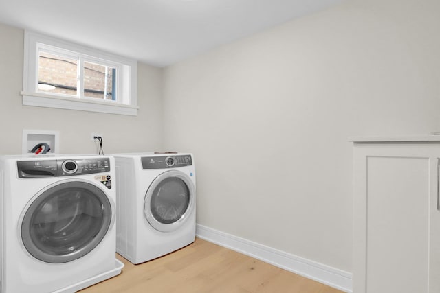 clothes washing area featuring light hardwood / wood-style floors and separate washer and dryer