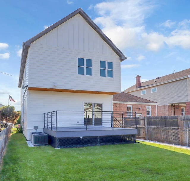 back of house with a deck, central air condition unit, and a yard