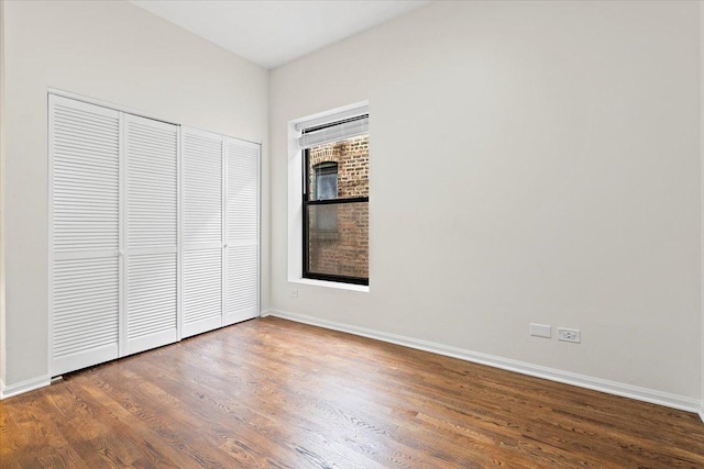 unfurnished bedroom with baseboards, a closet, and wood finished floors