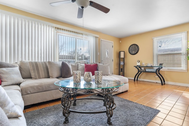 living area with a wealth of natural light, baseboards, light tile patterned flooring, and ceiling fan