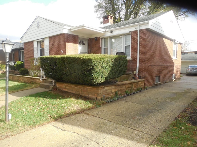 view of front of home featuring brick siding and a chimney