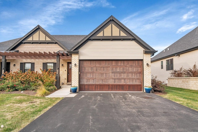 view of front of house with brick siding, a front lawn, driveway, and a garage