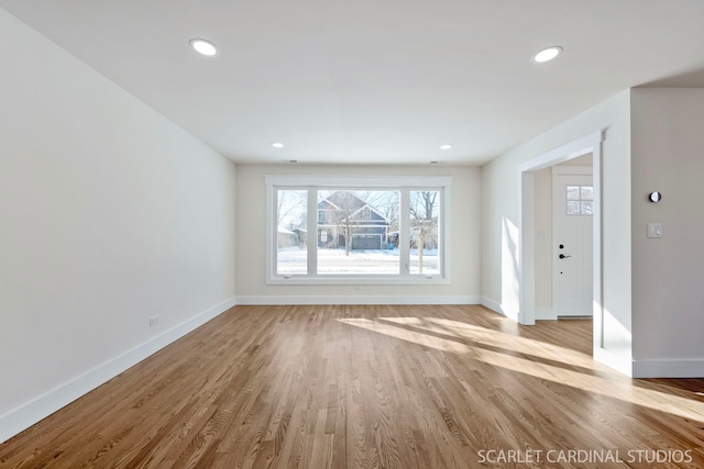 unfurnished living room featuring recessed lighting, light wood-style flooring, and baseboards