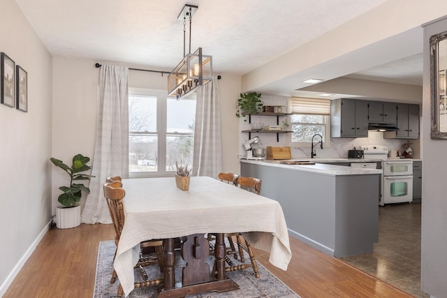 dining area with baseboards, a textured ceiling, and dark wood-type flooring