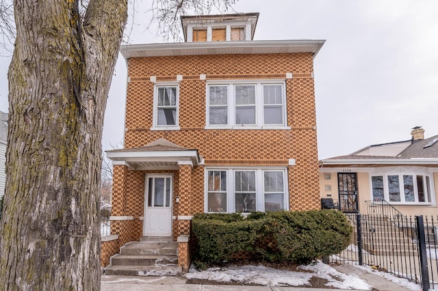 view of front of property with brick siding and fence