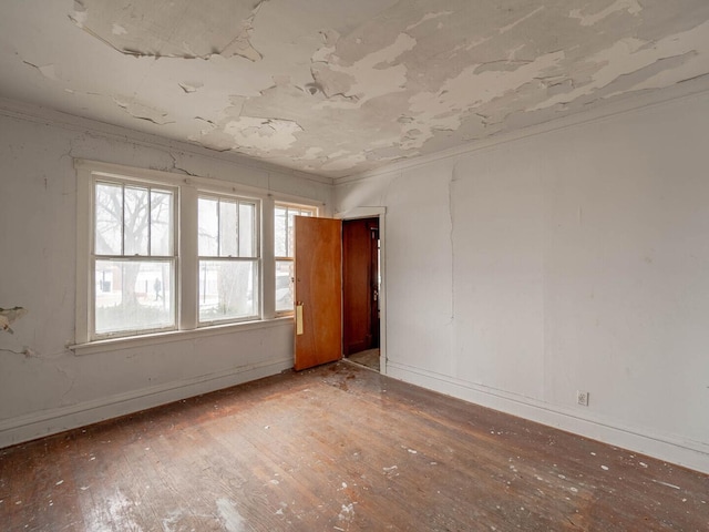 spare room featuring baseboards, crown molding, and light wood-style floors