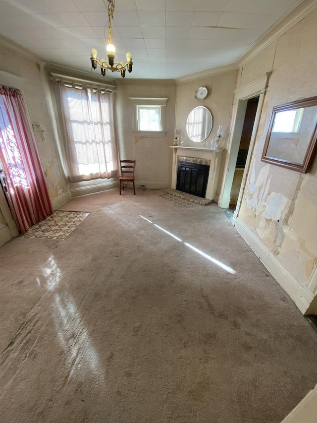 unfurnished living room featuring crown molding, a high end fireplace, a notable chandelier, and carpet