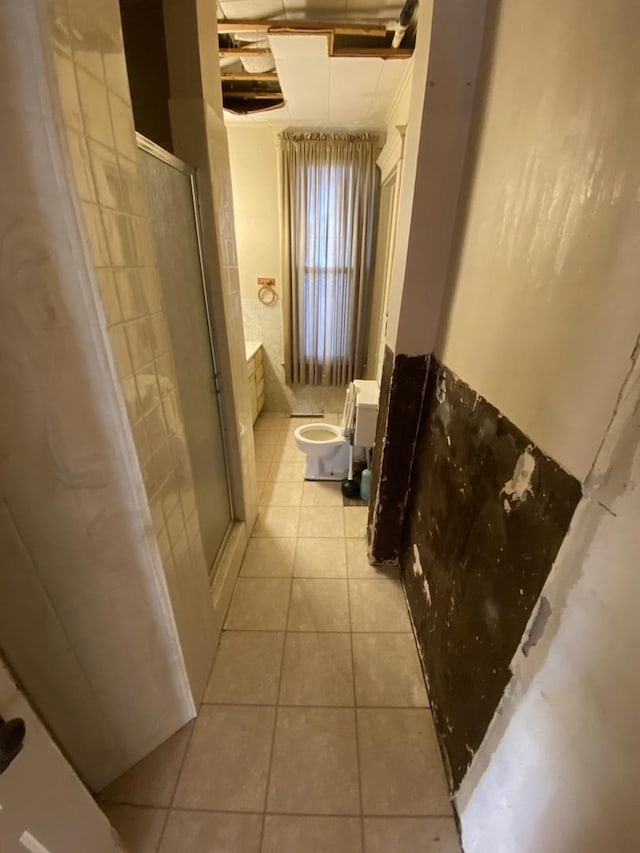 full bathroom featuring tile patterned flooring and a shower with door