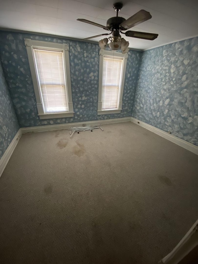 spare room featuring carpet flooring, ceiling fan, baseboards, and wallpapered walls