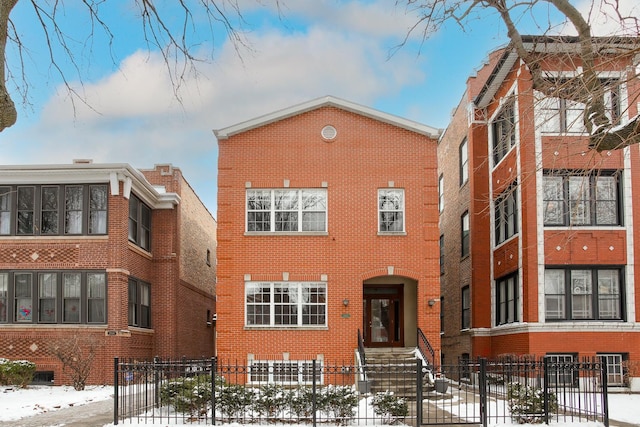 view of front of property with a fenced front yard and brick siding