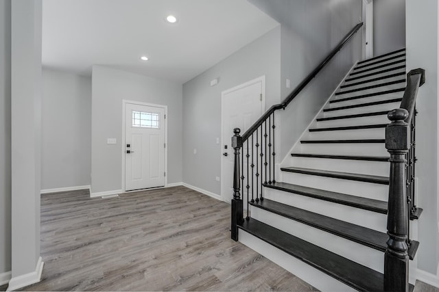 entrance foyer with light wood-style flooring, baseboards, recessed lighting, and stairway