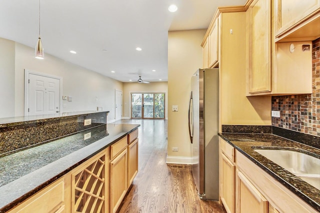 kitchen featuring light brown cabinets, wood finished floors, open floor plan, freestanding refrigerator, and decorative light fixtures