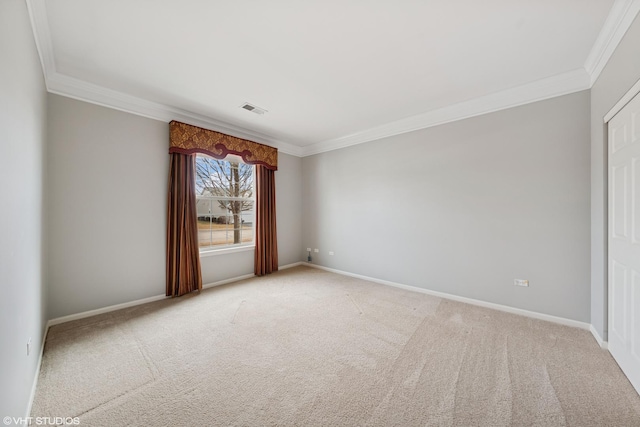 spare room featuring visible vents, ornamental molding, baseboards, and light colored carpet